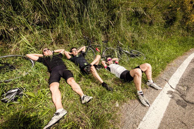 Three Lazy Cyclists Resting on Side of the Road