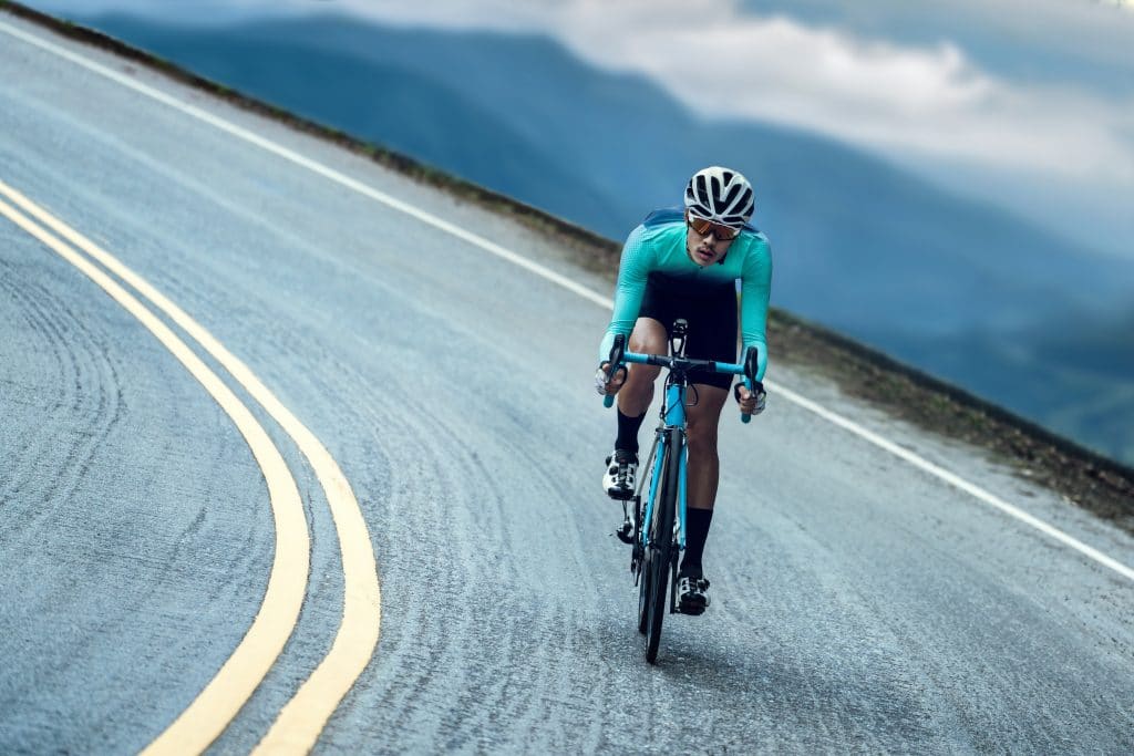 Cyclists are cycling, climbing up to the top.