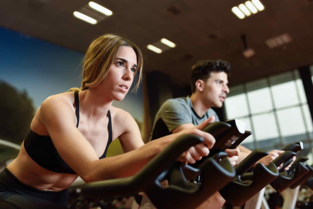 Couple in a spinning class wearing sportswear.