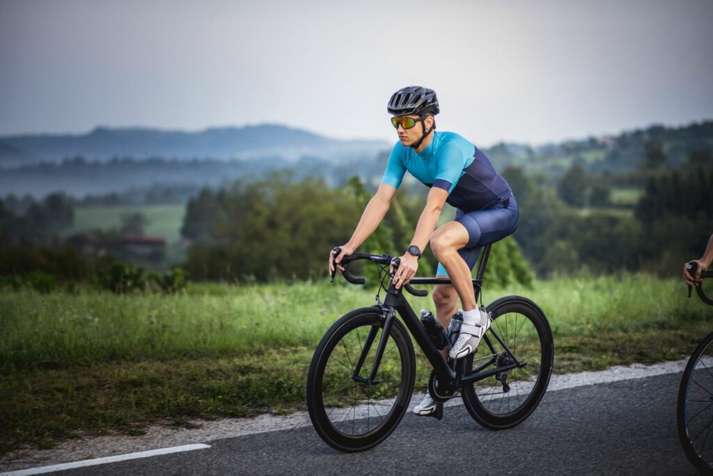 young-man-cycling-through-summertime-rural-royalty-free-image-1627486177