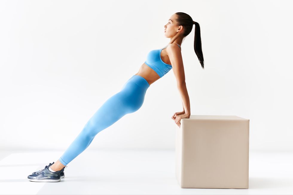 sporty-woman-making-reverse-plank-exercise-on-white-royalty-free-image-1673538308