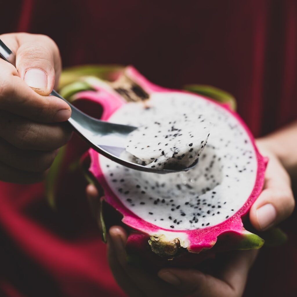 half-dragon-fruit-in-hand-eating-by-spoon-tropical-royalty-free-image-1692644399