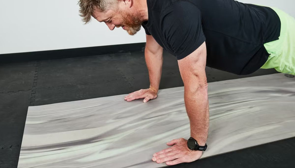 A man showing where his hands should be during a push-up