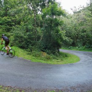 A cyclist riding up a switchback hill